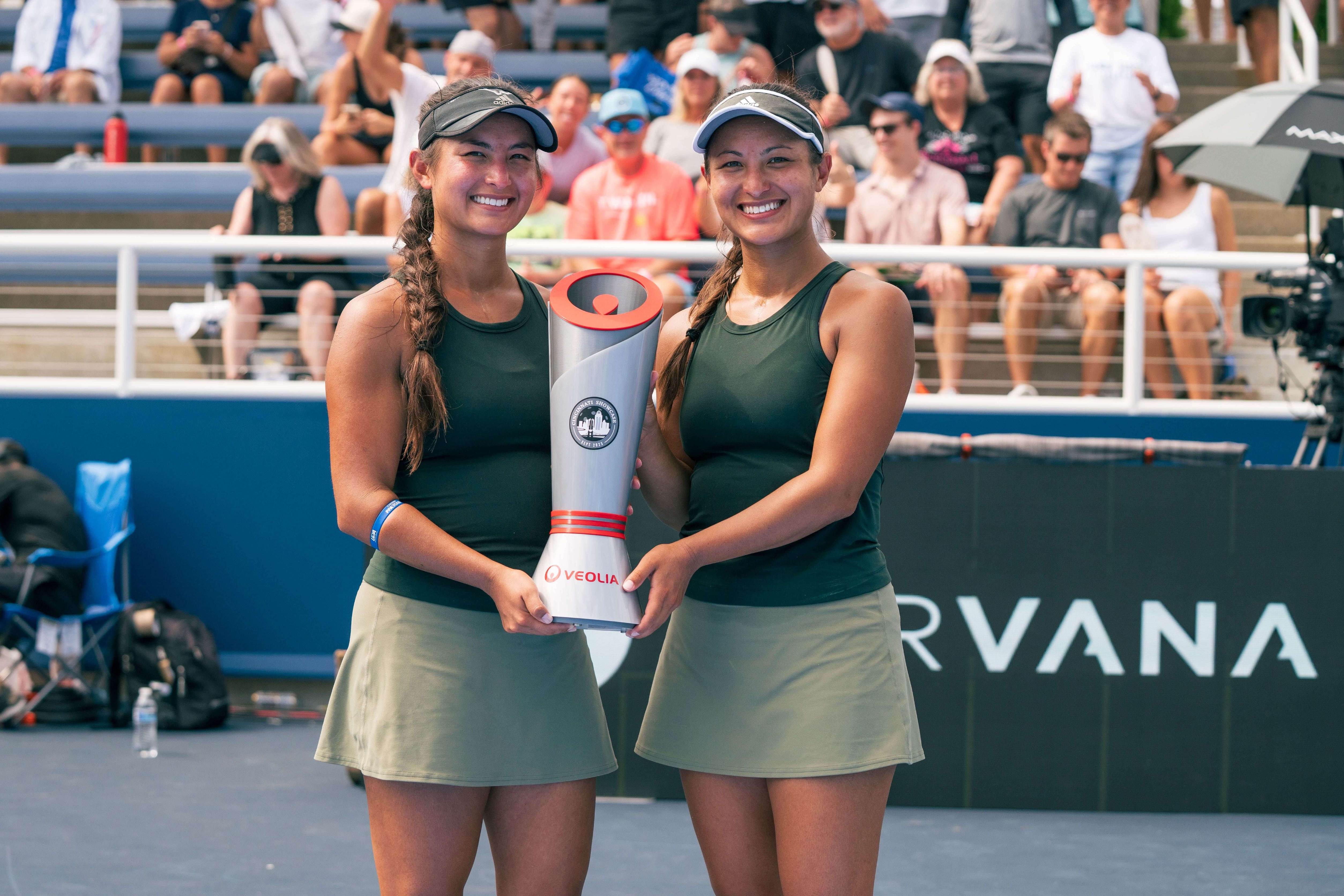 Jade and Jackie in matching dark green tank tops and light skirts